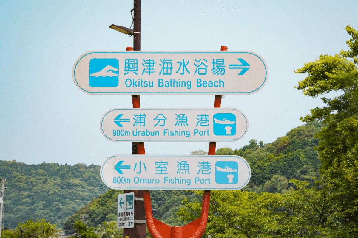 ป้ายถนนชี้ไปชายหาดโอกิตสึและท่าเรือใกล้เคียง