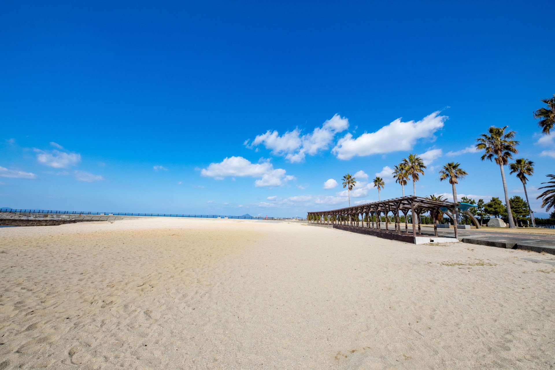 หาดทรายสีขาว ต้นปาล์ม และทะเลที่สวนริมทะเลโกะชิกิฮิเมะ