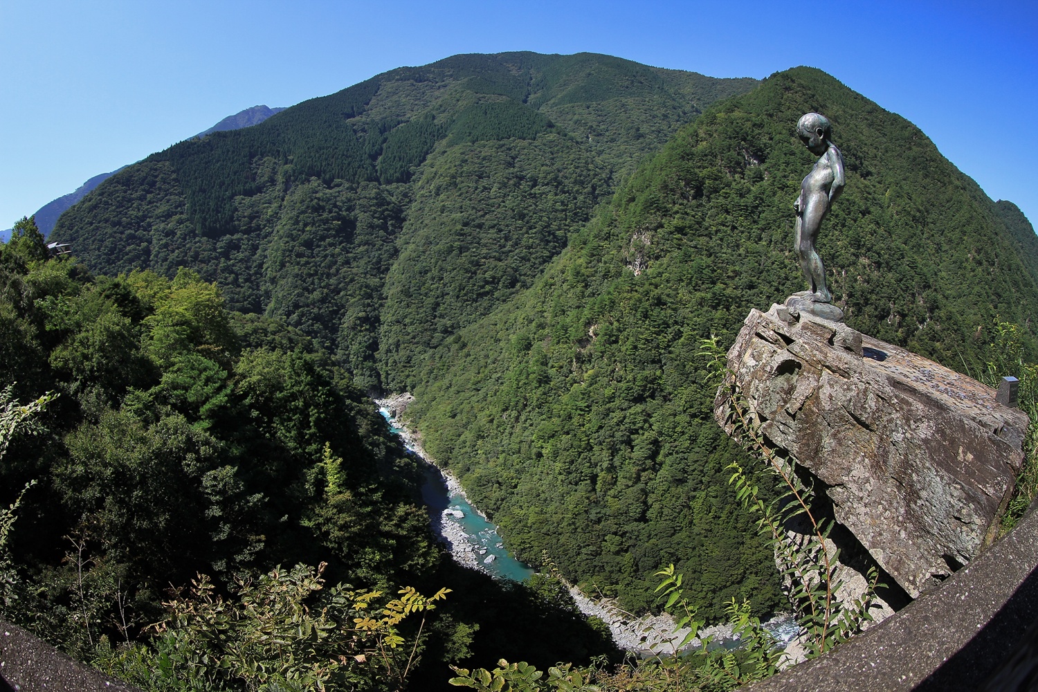 รูปปั้น The Peeing Boy of Iya Gorge บนโขดหินเหนือหุบเขาอิยะและแม่น้ำด้านล่าง