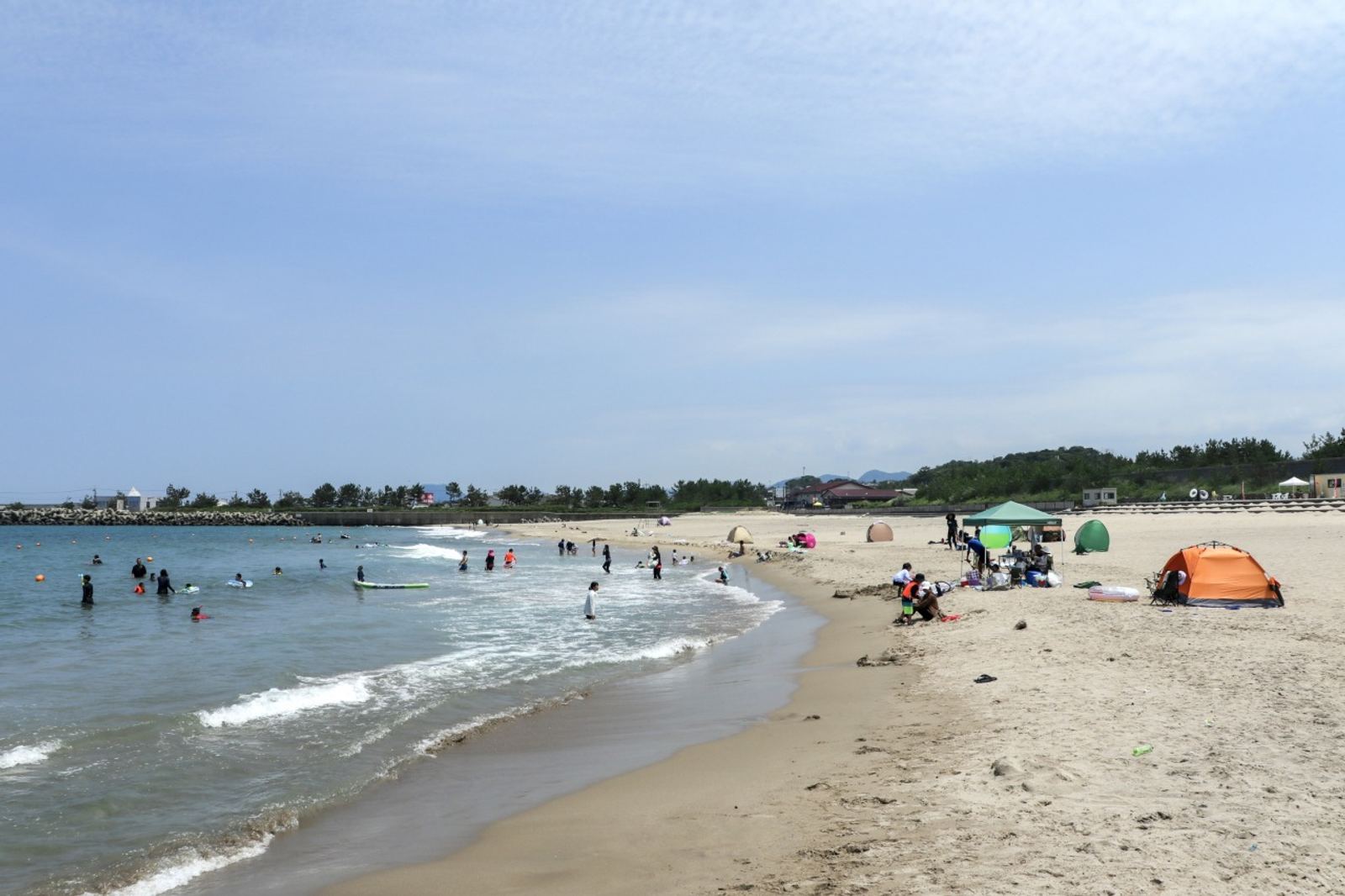 บรรยากาศชายหาดคาโระมินาโตะที่มีคนลงเล่นน้ำ