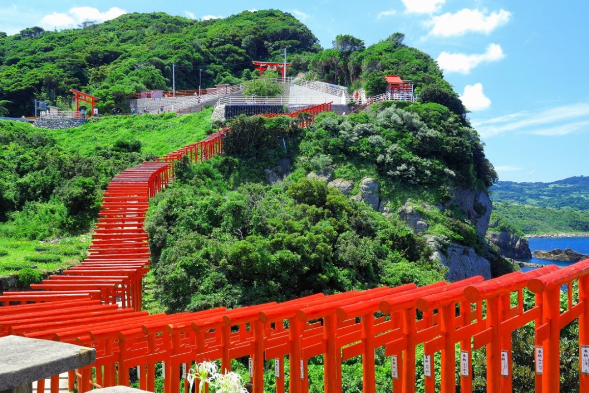 แถวเสาโทริอิสีแดงเรียงลงเนินสู่ทะเลที่ศาลเจ้าโมโตโนซูมิ
