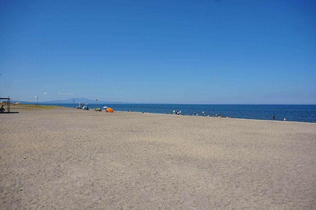 พระอาทิตย์ตกเหนือทะเลญี่ปุ่นและชายหาดทรายที่หาดคามายะฮามะ เมืองมิตาเนะ จังหวัดอาคิตะ