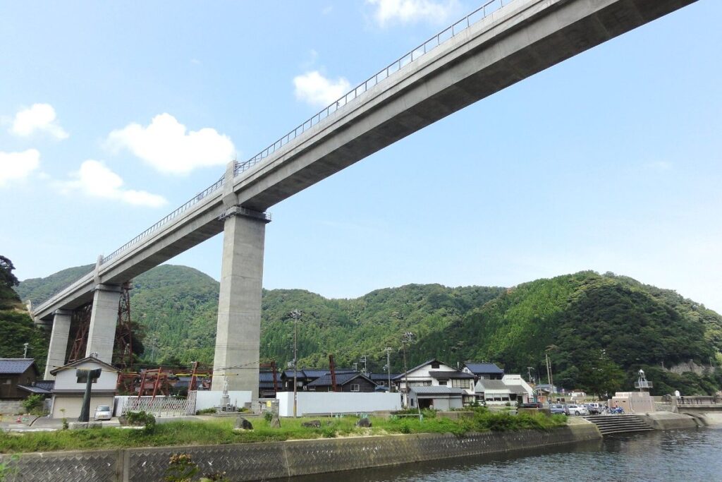 สะพานคอนกรีตอามารุเบะสูงเหนือหมู่บ้านริมทะเล