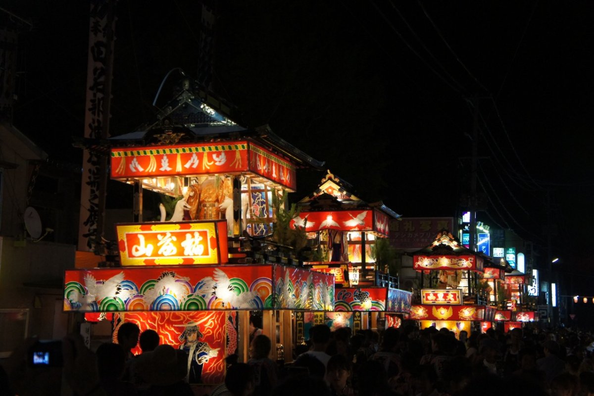 รถแห่ขนาดใหญ่ในเทศกาลทานาบุ เมืองมุตสึ ขบวนเคลื่อนผ่านถนนในเมืองยามค่ำ