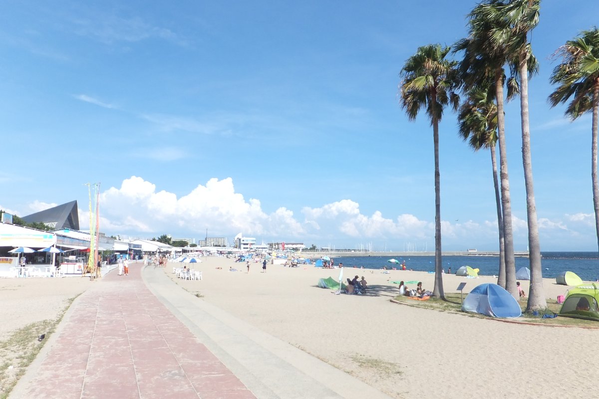 หาดทรายสุมะเมืองโคเบช่วงฤดูร้อน มีคนเล่นน้ำทะเลและกางร่มบนชายหาด