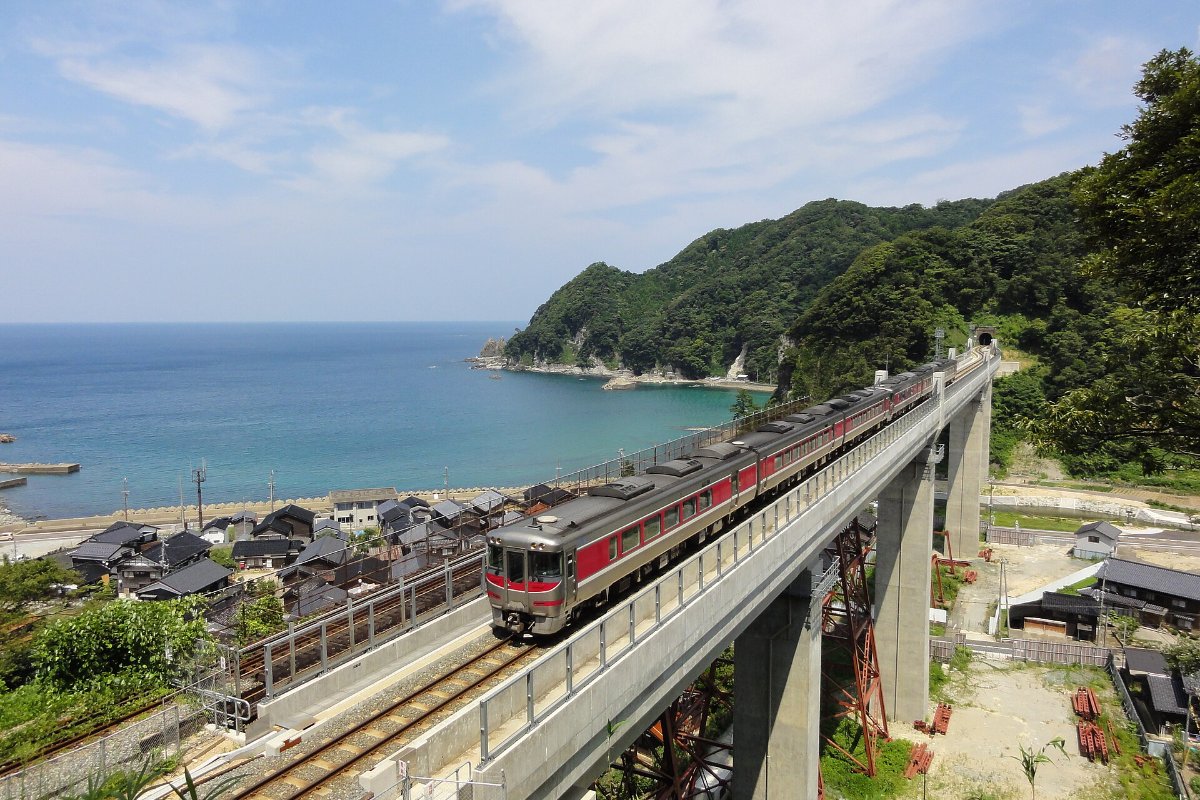 สะพานรถไฟอามารุเบะและสถานีบนฟ้าเหนือหมู่บ้านริมทะเลในฤดูหนาว