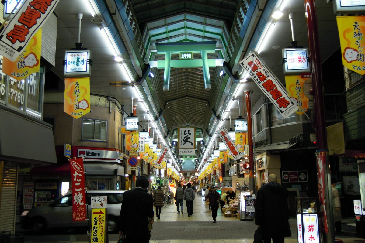 ถนนช้อปปิ้งเท็นจินบาชิสุจิ เขตคิตะ โอซาก้า ทางเดินมีหลังคาคลุมยาวและร้านค้าเรียงสองฝั่ง