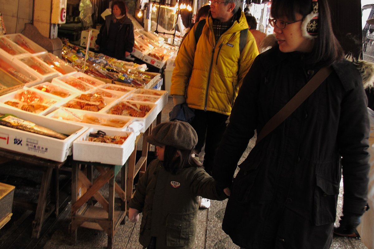 ผู้คนเดินชมแผงอาหารทะเลในตลาดนิโจ
