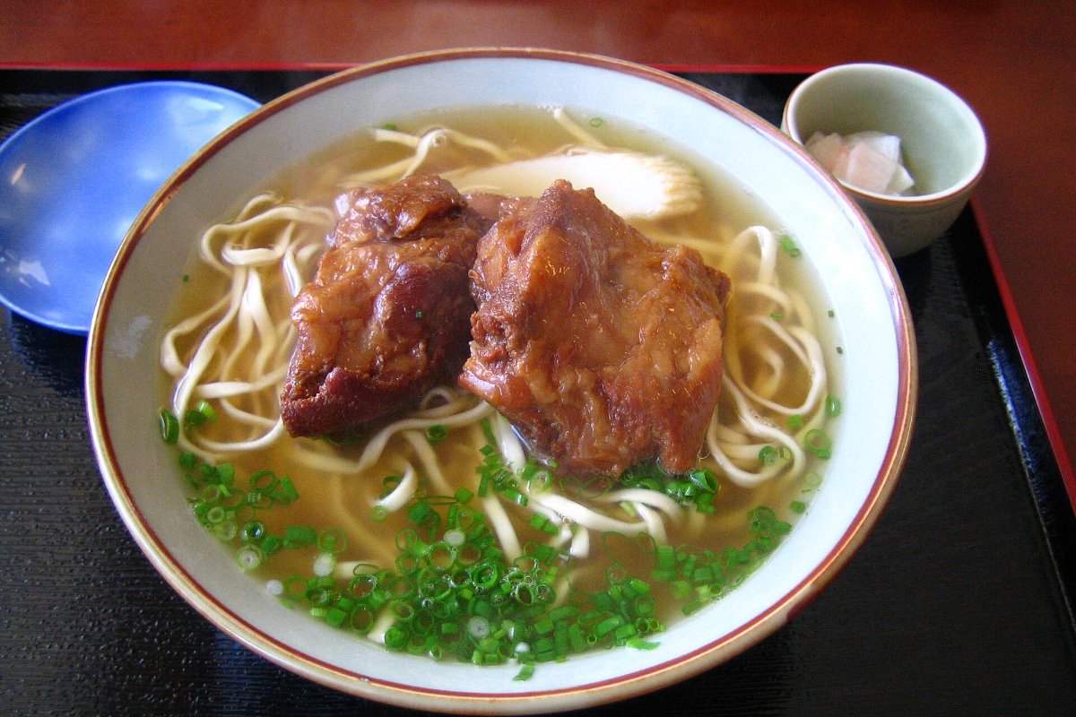 โซกิโซบะในชามใหญ่ มีซี่โครงหมูเคี่ยวชิ้นโตวางบนเส้น ร้านต้นตำรับที่นาโงะ โอกินาว่า