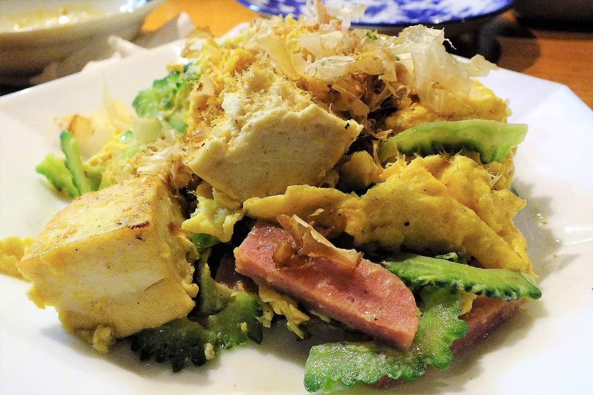 มะระผัดกับเต้าหู้ ไข่ และหมูในจาน เสิร์ฟพร้อมข้าวและซุปเป็นชุด ร้านอาหารในนาฮะ