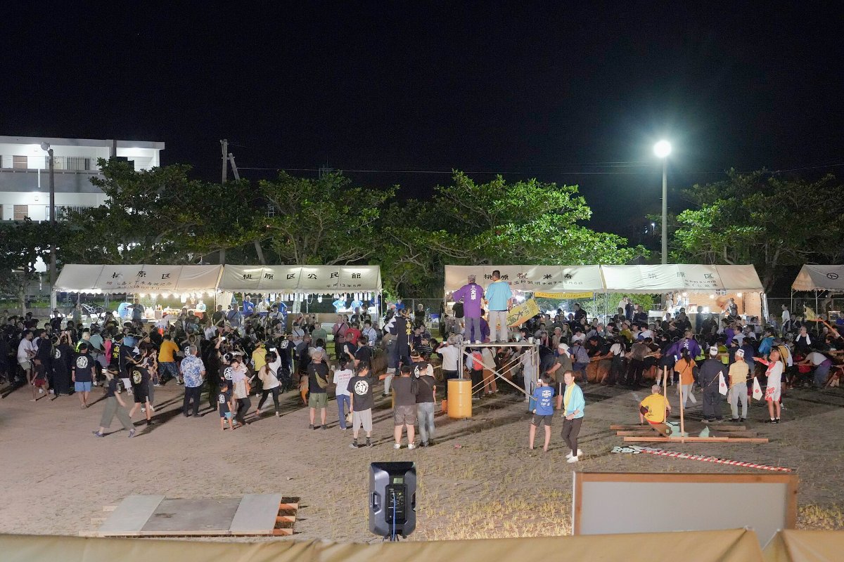 เวทีกลางแจ้งยามเย็นในสวนเนมะ มีผู้คนนั่งชมการแสดงในงานฤดูร้อนมิยาโกะจิมะ