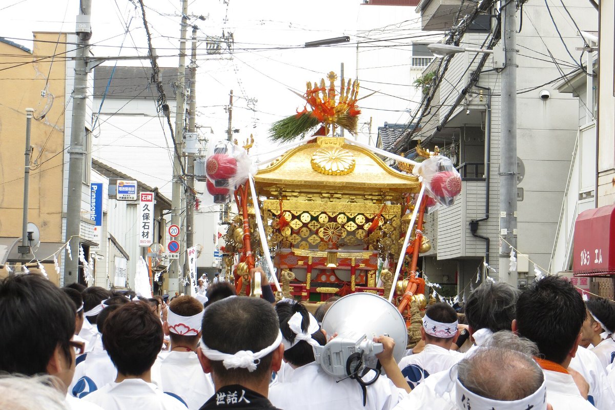 ขบวนมิโคชิของศาลเจ้าซุมิโยชิไทฉะแห่ไปตามถนน มีคนในชุดเทศกาลแบกเกี้ยวในเทศกาลซุมิโยชิ โอซาก้า