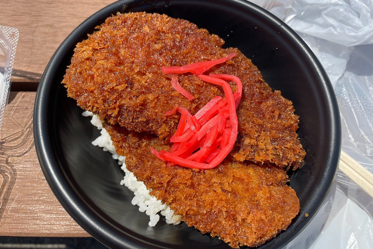 หมูทอดชิ้นใหญ่บางสองชิ้นวางซ้อนบนข้าวในชาม ราดซอส ข้าวหน้าวาราจิคัตสึ เมืองโองาโนะ