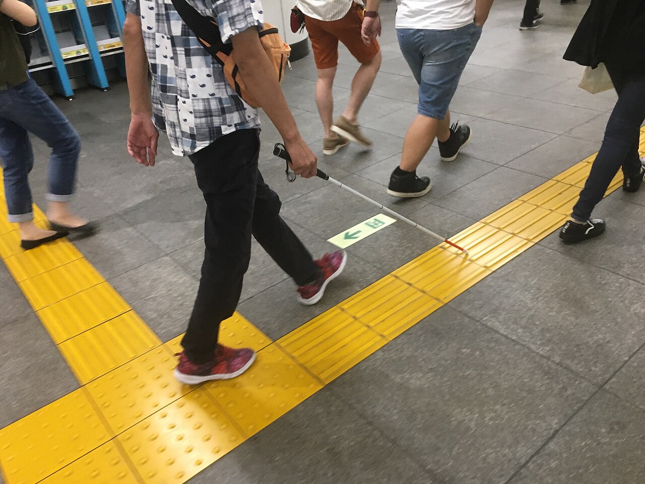ไม้เท้าขาวใช้แนวพื้นนูนสีเหลืองช่วยนำทางในพื้นที่โตเกียว