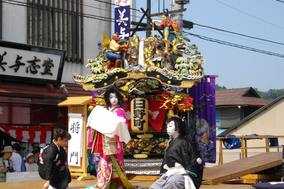 ฉากภูเขาขนาดใหญ่ตั้งกลางถนน นักแสดงชุดคาบูกิร่ายรำต่อหน้าผู้ชม ในงานยามาอาเงะ เมืองนาสึคาราสึยามะ