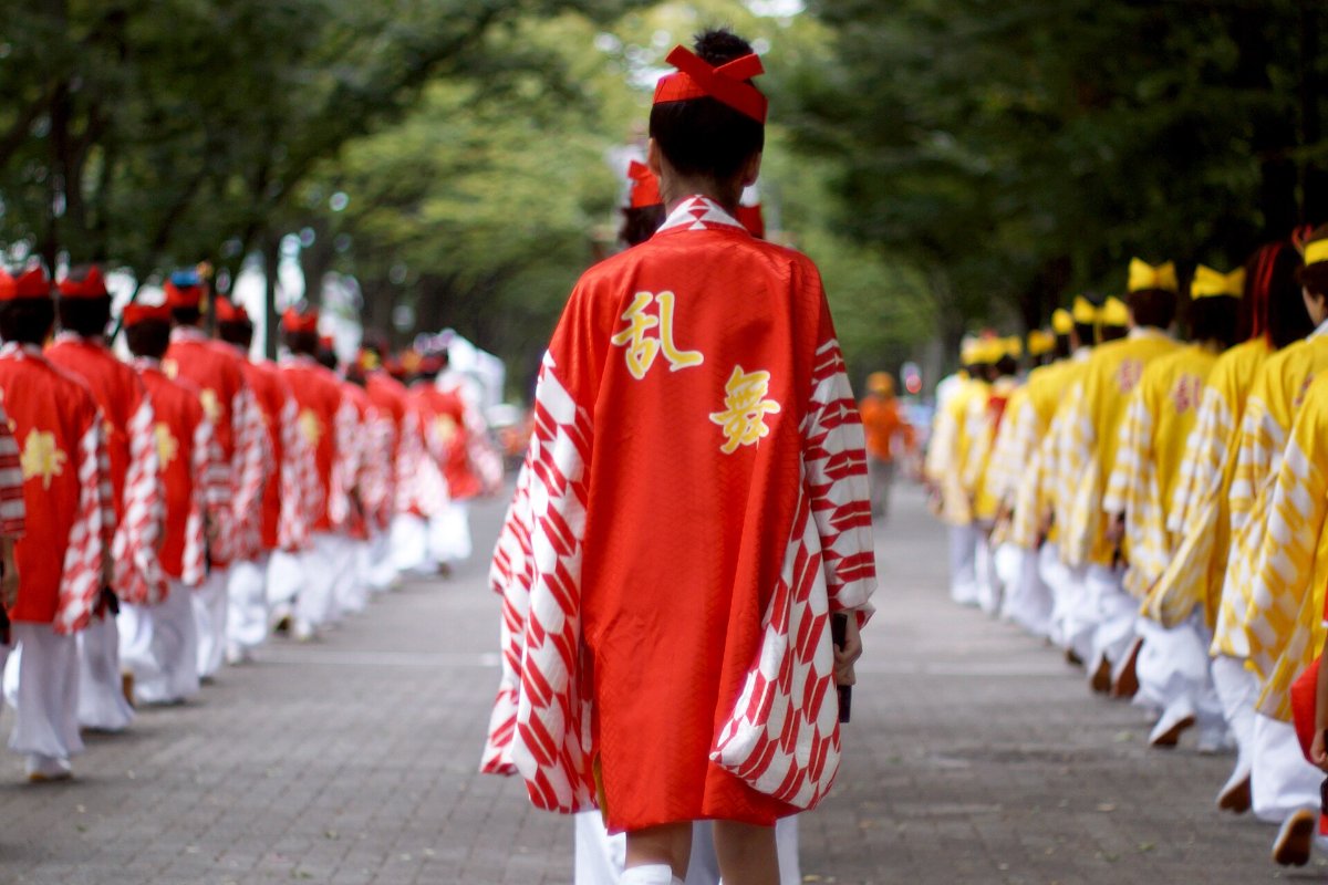 ทีมนักเต้นโยซาโคอิในชุดสีสดเต้นรำบนถนนหน้าสถานีอิเคบุคุโระ โตเกียว