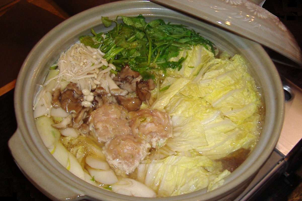 หม้อจังโกะนาเบะใส่ผัก ไก่ และลูกชิ้นเดือดบนโต๊ะ ร้านย่านเรียวโงกุ โตเกียว