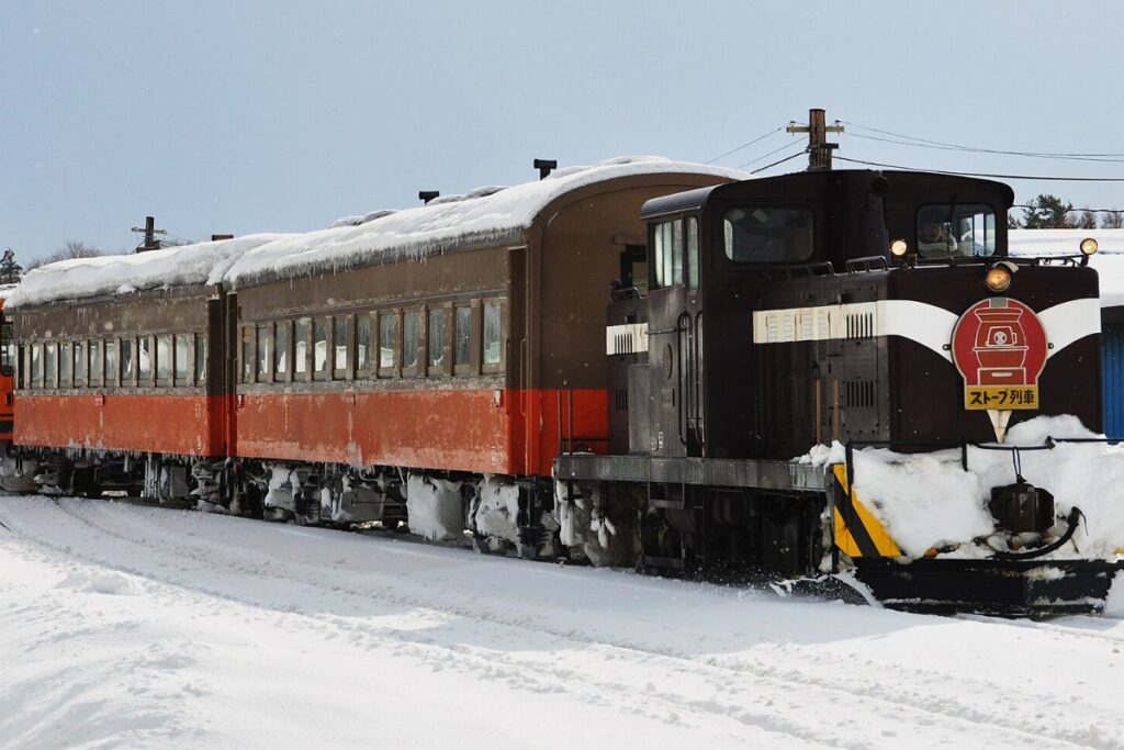 รถไฟเตาถ่านสึการุวิ่งผ่านทุ่งหิมะ ตู้โดยสารรุ่นเก่ามีเตาถ่านหินอยู่กลางตู้
