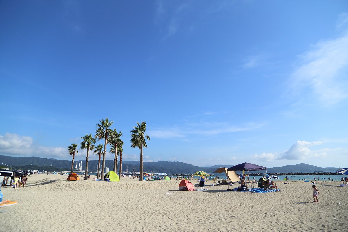 หาดทรายยาวของหาดคาตาโอนามิ ย่านวาคาโนะอุระ เมืองวาคายามะ มีคนเล่นน้ำทะเล
